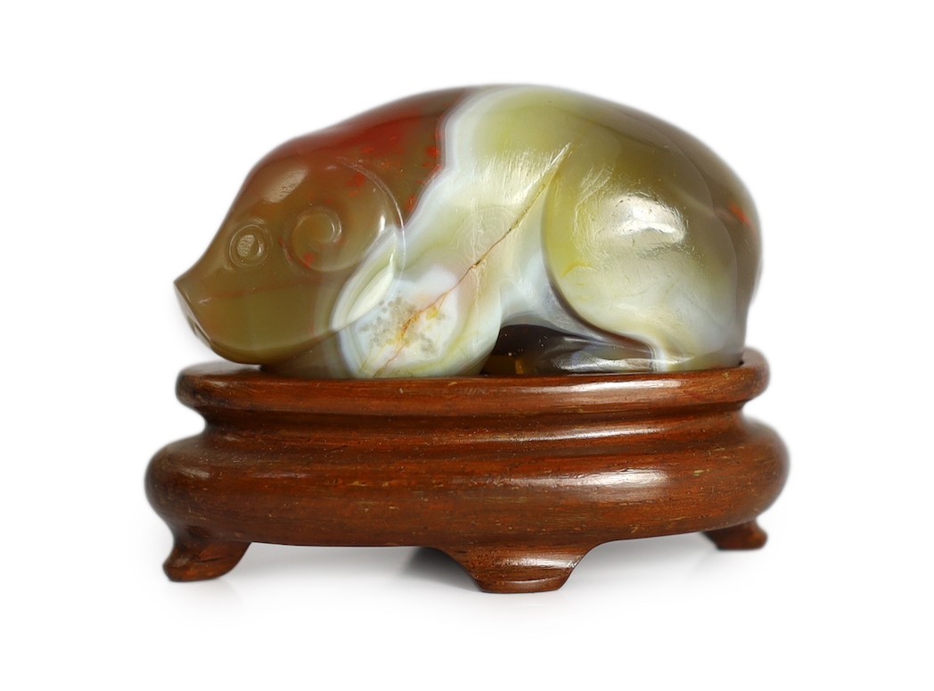 A Chinese banded agate figure of a recumbent pig, 18th/19th century, 5.4cm long, wood stand